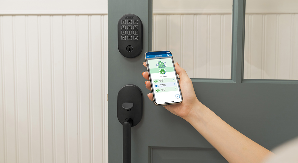 Person using the Schlage Home App on their phone to unlock their Schlage Arrive smart keypad deadbolt