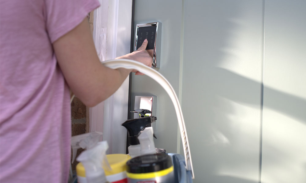 House cleaner using smart lock to access Airbnb for cleaning.