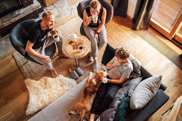 family-talking-in-living-room-with-coffee-and-dog-min