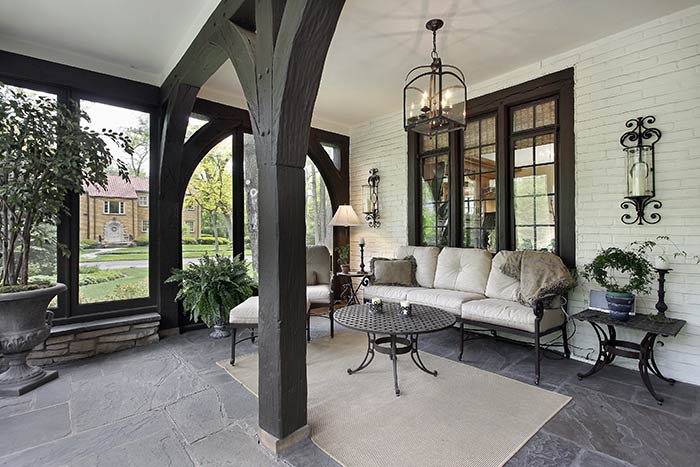 Porch breezeway decorated with patio furniture.