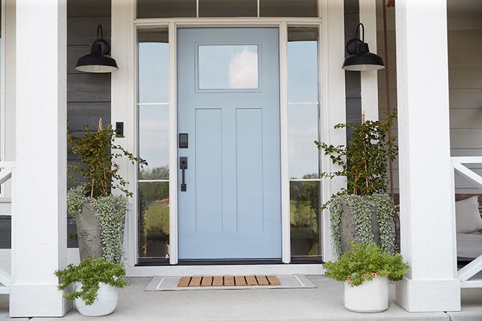 Light blue front door with a matte black smart lock and door handle. 